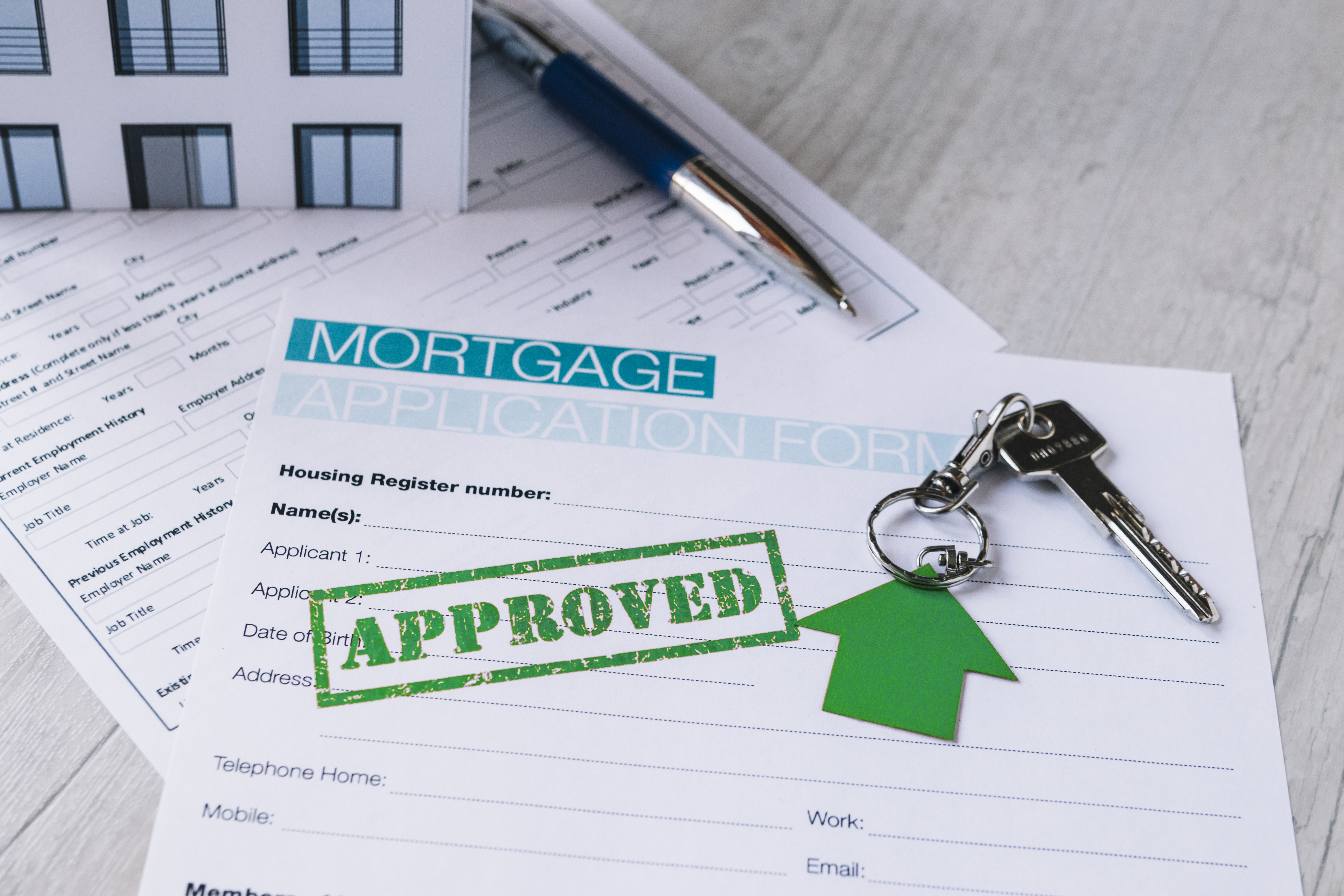 Homebuyer reviewing mortgage documents after starting a new job with a loan officer.