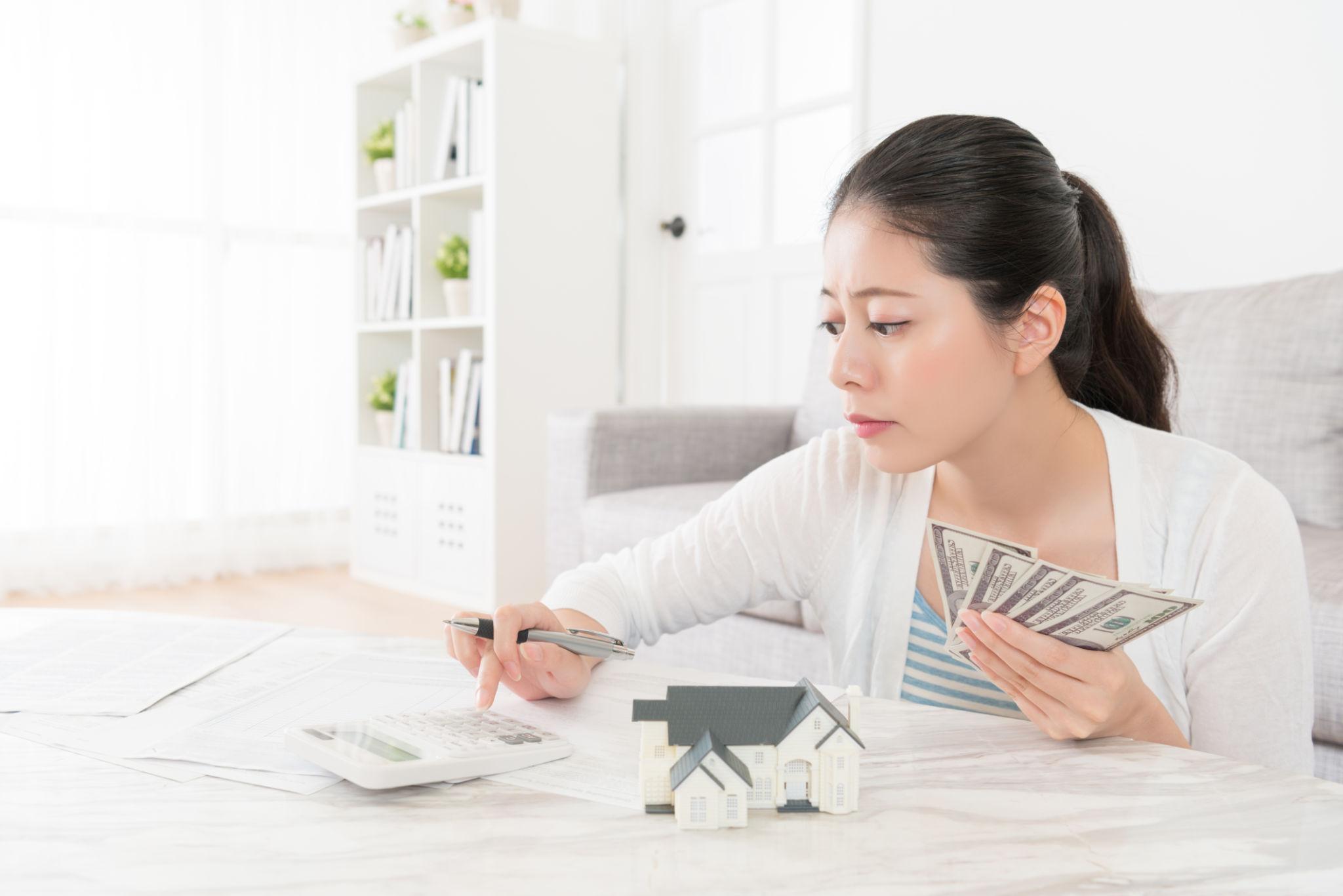 Homebuyer calculating a down payment for a home purchase with mortgage documents