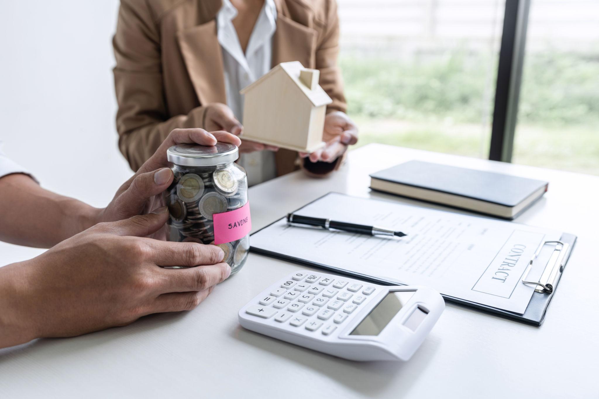 Homebuyer preparing finances for homeownership with mortgage documents and calculator